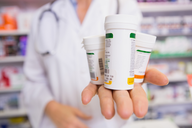 pharmacist holding pill bottles in palm